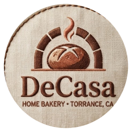 The DeCasa logo — a loaf in a brick oven, stitched on a linen patch.
